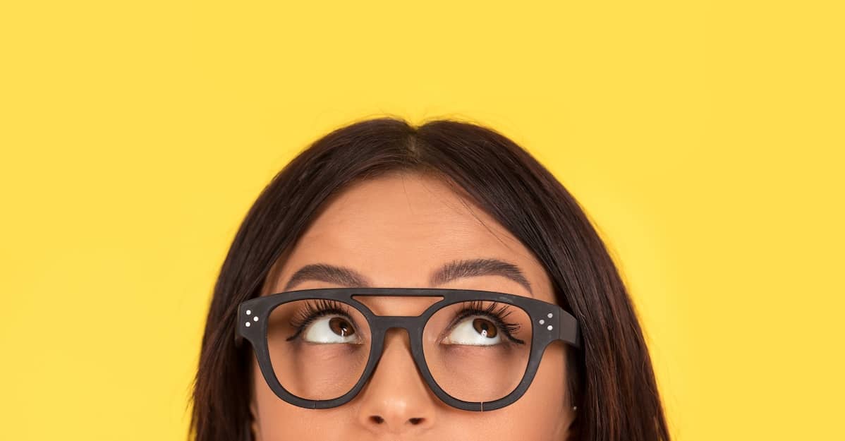 woman with glasses wondering, "Does LASIK hurt?"