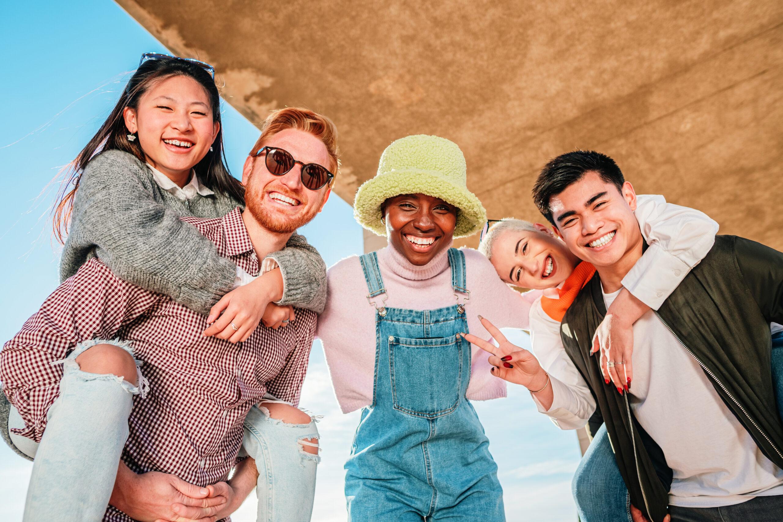 Group of five multiracial friends smiling and having fun looking at camera.